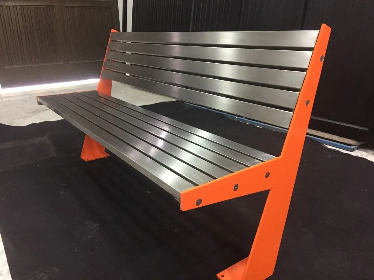 Fabricated stainless steel bench with an orange powder-coated frame