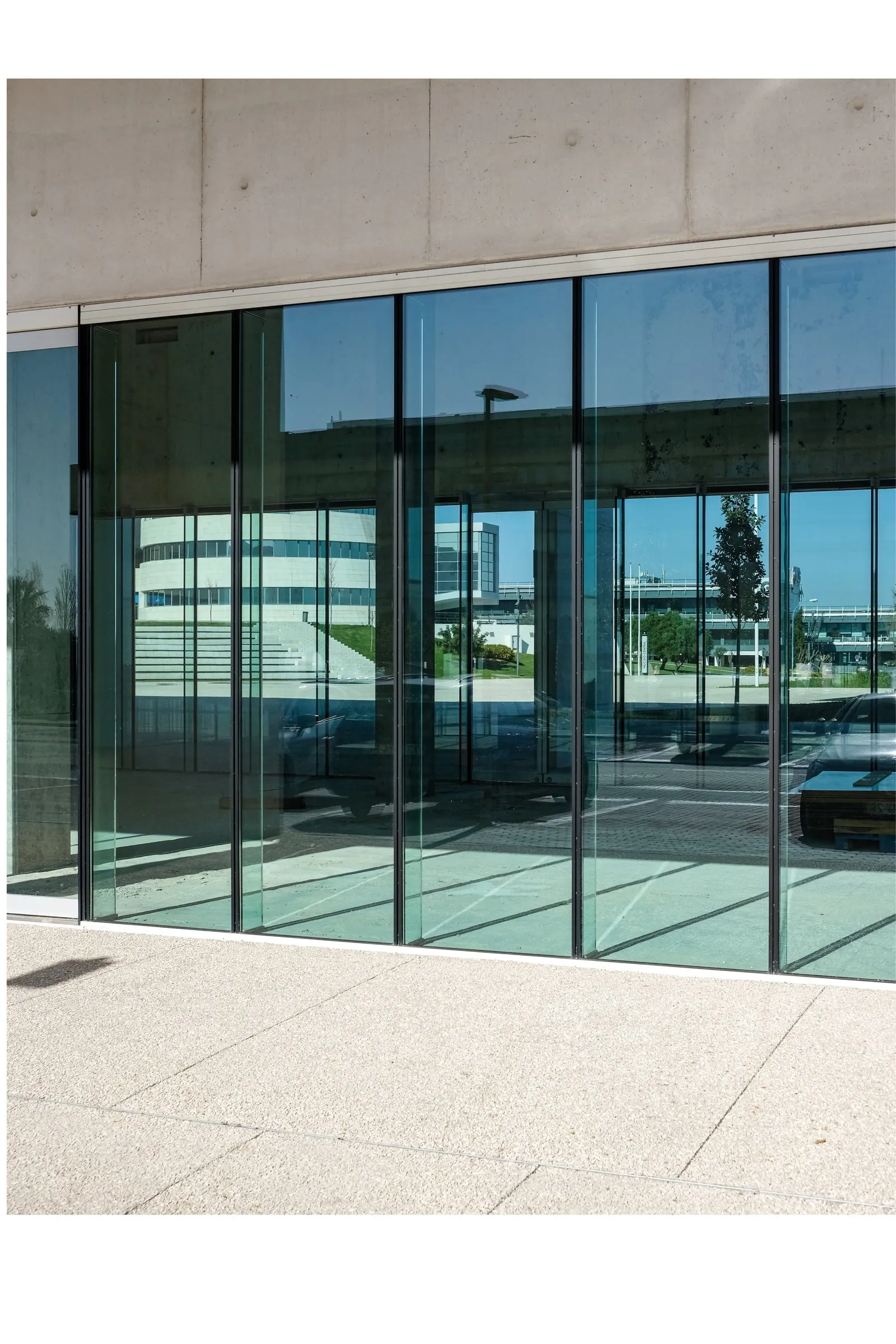 Commercial storefront in structural glass with stainless steel entrance framing